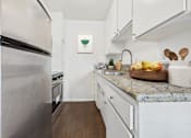Thumbnail 3 of 81 - A kitchen with a stainless steel refrigerator and white cabinets.