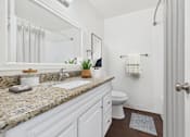 Thumbnail 12 of 81 - A bathroom with a marble countertop and white fixtures.