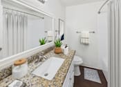 Thumbnail 11 of 81 - A bathroom with a granite countertop and a white sink.