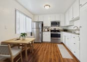 Thumbnail 14 of 81 - A kitchen with white cabinets and a wooden table.