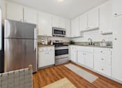 Thumbnail 13 of 81 - A kitchen with white cabinets and a stainless steel refrigerator.