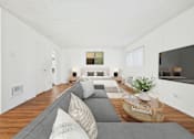 Thumbnail 17 of 81 - A living room with a grey couch and a coffee table.
