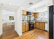 Thumbnail 5 of 24 - A kitchen with wooden floors and white walls.