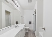 Thumbnail 6 of 16 - A white bathroom with a sink, toilet, and mirror.