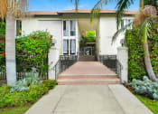 Thumbnail 8 of 17 - a house with palm trees and a sidewalk in front of it