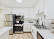 Thumbnail 1 of 29 - A kitchen with white cabinets and a black stove.
