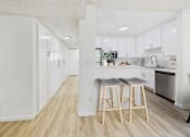 Thumbnail 2 of 29 - A kitchen with white cabinets and a wooden floor.
