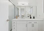 Thumbnail 11 of 29 - A white bathroom with a sink and mirror.