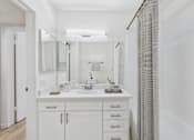 Thumbnail 12 of 29 - A white bathroom with a double sink and a large mirror.