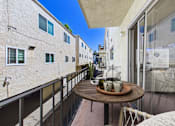 Thumbnail 6 of 29 - A balcony with a table and chairs overlooking a street.