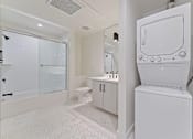 Thumbnail 93 of 119 - A white bathroom with a toilet, sink, and shower.