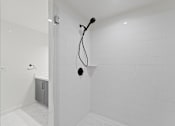 Thumbnail 40 of 119 - A white tiled bathroom with a shower head and hand held shower.
