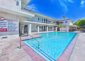 Thumbnail 87 of 90 - A pool in front of a building with a sign on the wall.