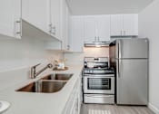 Thumbnail 1 of 73 - A modern kitchen with a stove, oven, and refrigerator.