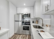 Thumbnail 6 of 73 - A modern kitchen with stainless steel appliances and white cabinetry.
