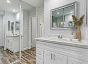 Thumbnail 9 of 73 - A bathroom with a vanity, sink, and mirror.