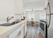 Thumbnail 2 of 90 - A modern kitchen with a stainless steel oven and white cabinets.