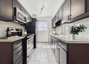 Thumbnail 15 of 95 - A kitchen with dark brown cabinets and white countertops.