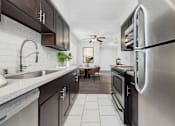 Thumbnail 14 of 95 - A modern kitchen with a stainless steel refrigerator and black cabinets.