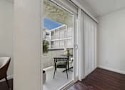 Thumbnail 20 of 95 - A chair and table are set up on a balcony.