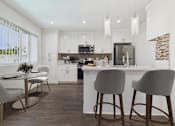 Thumbnail 3 of 91 - A modern kitchen with white cabinets and a bar area.