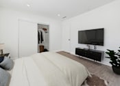 Thumbnail 7 of 91 - A bedroom with a large bed and a flat screen TV mounted on the wall.