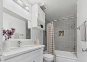 Thumbnail 10 of 91 - A white bathroom with a toilet, sink, and shower.