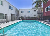 Thumbnail 53 of 91 - A swimming pool in front of a white and red building.