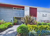 Thumbnail 50 of 91 - The Hideaway building with a red door and a sign on the wall.