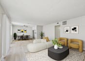 Thumbnail 5 of 50 - A living room with a white couch, a black coffee table, and a rug.