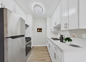 Thumbnail 1 of 50 - A kitchen with white cabinets and a black refrigerator.