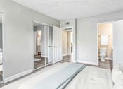 Thumbnail 23 of 50 - a bedroom with a white bed and a bathroom with a toilet