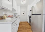 Thumbnail 1 of 60 - A kitchen with white cabinets and a fridge.