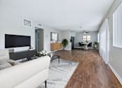Thumbnail 3 of 60 - A living room with a white couch and a television.