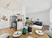 Thumbnail 5 of 9 - A modern kitchen with a dining table set for two.