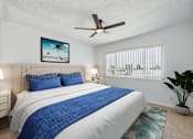Thumbnail 4 of 29 - A bedroom with a large bed and a ceiling fan.