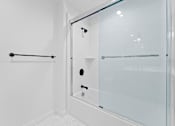 Thumbnail 55 of 119 - A white bathroom with a glass shower door.
