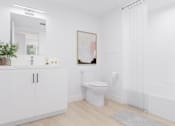 Thumbnail 11 of 20 - A white bathroom with a toilet, a cabinet, a plant, and a painting on the wall.