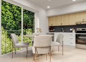 Thumbnail 4 of 20 - A modern kitchen with a table and chairs by a window.