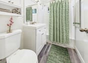 Thumbnail 9 of 36 - A white toilet sits next to a white cabinet in a bathroom.