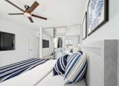 Thumbnail 3 of 29 - A bedroom with a bed, pillows, and a ceiling fan.