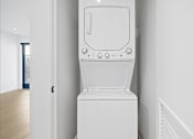 Thumbnail 117 of 119 - A white washing machine in a room with white walls.
