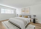 Thumbnail 6 of 44 - A bedroom with a large bed and a small table with a lamp on it.