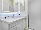 Thumbnail 9 of 44 - A white bathroom with a sink and mirror.