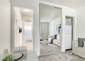Thumbnail 8 of 24 - a living room with mirrors and a couch and a table