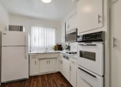 Thumbnail 12 of 24 - an empty kitchen with white appliances and white cabinets