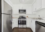 Thumbnail 1 of 35 - A modern kitchen with stainless steel appliances and white cabinets.
