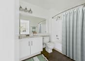 Thumbnail 10 of 35 - A white bathroom with a toilet, sink, and shower.