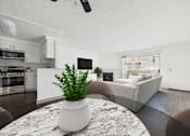 Thumbnail 2 of 35 - A plant in a white pot sits on a marble table in a modern kitchen and living room.