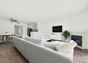 Thumbnail 7 of 35 - A living room with a white couch and a fireplace.